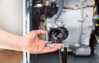 Kỹ thuật viên kiểm tra bơm xả máy giặt Hitachi bị nghẹt