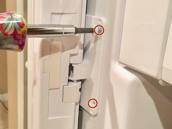 Kỹ thuật viên siết lại bản lề cửa tủ lạnh Hitachi bị lỏng