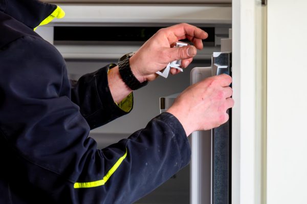 Kỹ thuật viên sửa bản lề cửa tủ lạnh Hitachi bị hỏng nặng